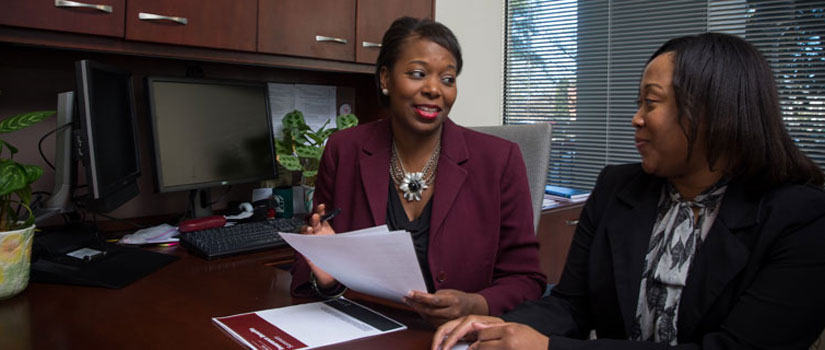 Supervisor with employee, reviewing their benefits options. 