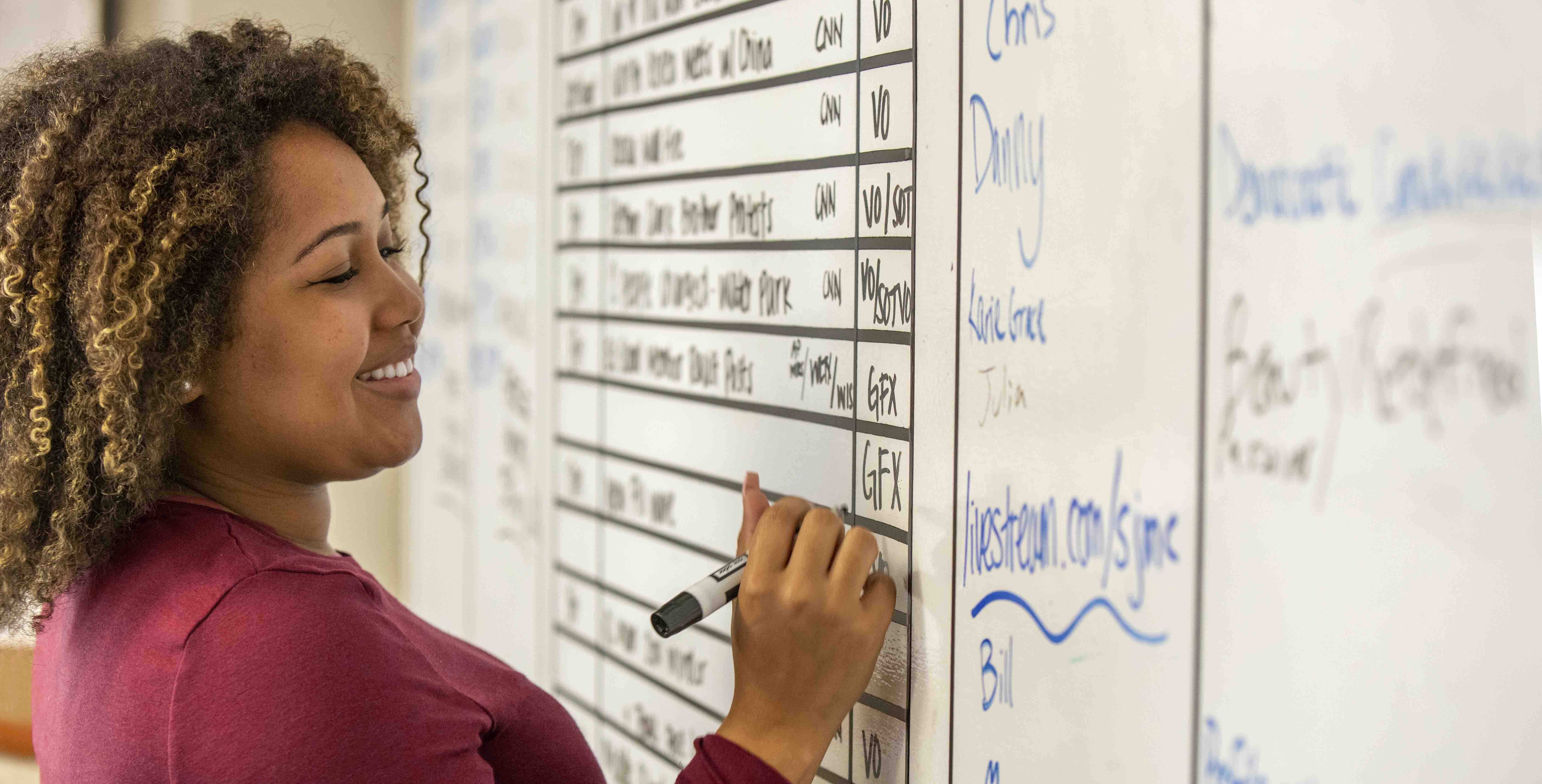 student writing on marker board in school of journalism and mass communications