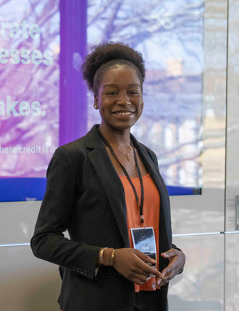 Student wearing a business suit smiling at the camera. 