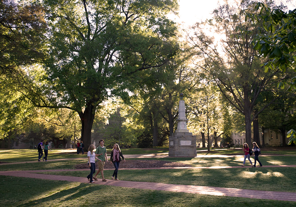 The historic horseshoe is beautiful green space full of live oak trees and the Maxcy Monument and people walking down the brick pathways. 