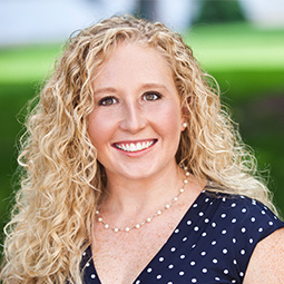 a woman with blond hair and a navy blue dress on