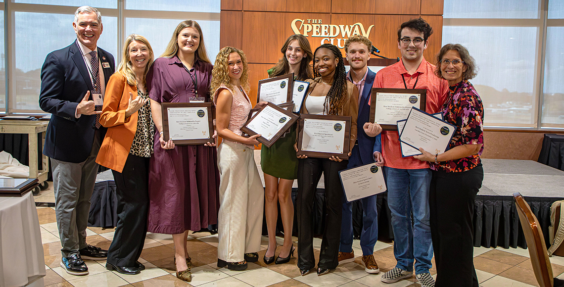 students holding their awards