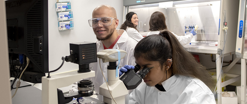 a female student smiles in a lab