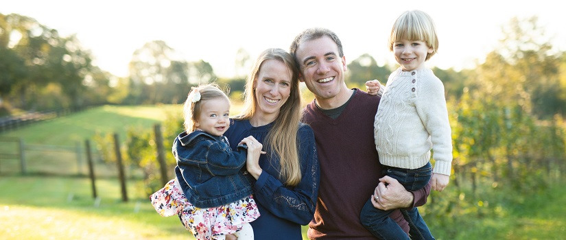 Aaron Hark stands with his wife and two kids.