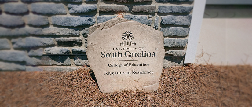 Close up of a stone plaque that has the USC College of Education logo with "Educators in Residence" written under the logo.