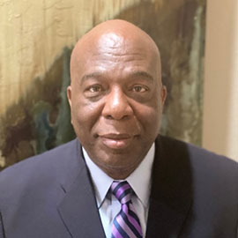 Larry Thomas, in a close headshot, faces the camera, smiling