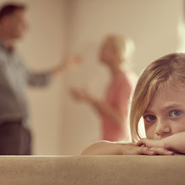 child with parents arguing in the background