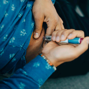 Photo of midsection of a person while they inject insulin