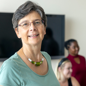 head and shoulders of angela liese with students in the background