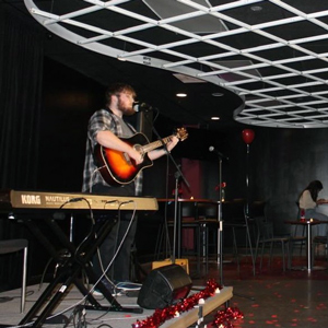 A man plays guitar on stage. 