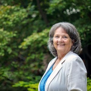 woman standing outside with trees in the background