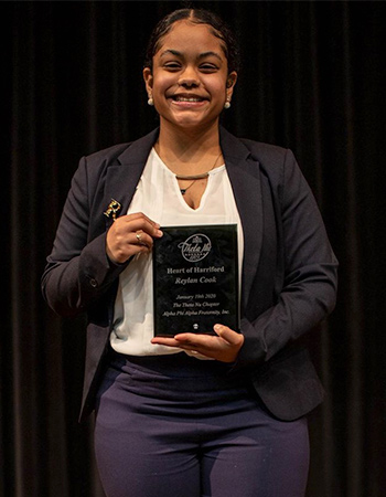 Portrait of Reylan Cook holding an award.