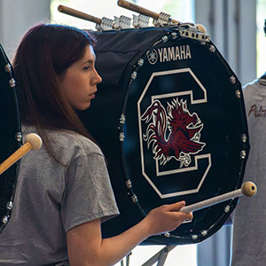 Female student playing a drum