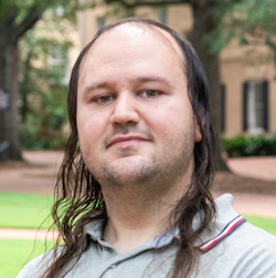 man with long hair smiling