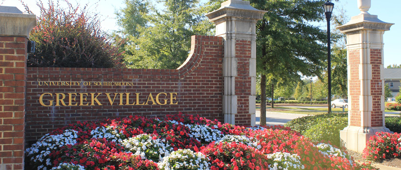 Greek Village entrance with flowers around brick gate