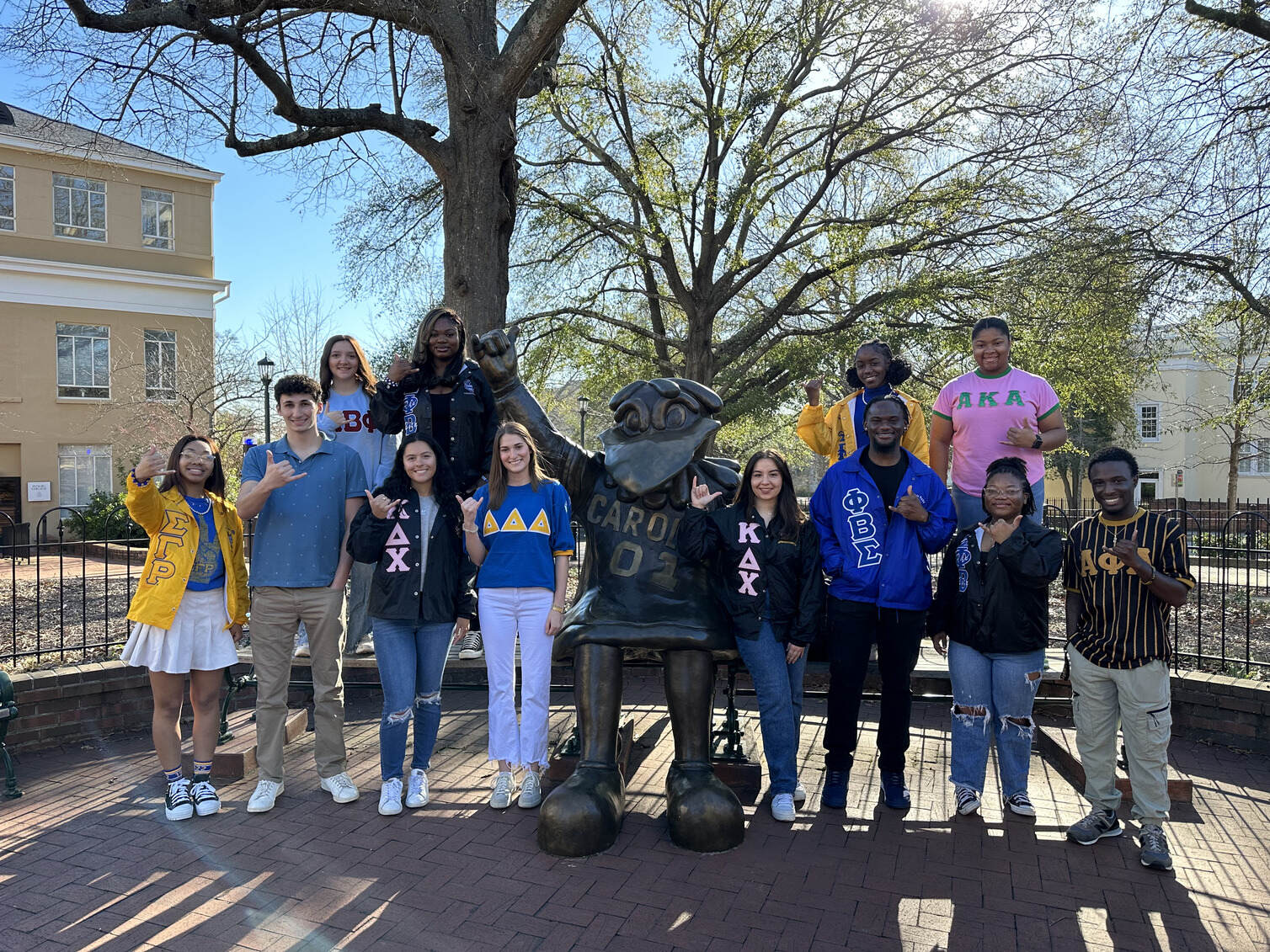A group of Greek students spend time together walking through campus.