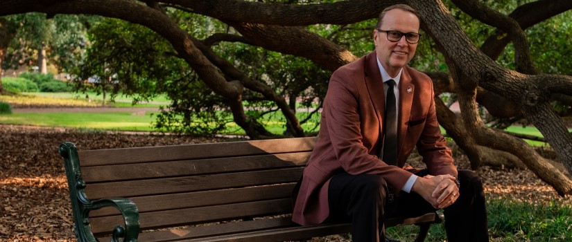 Portrait of Dr. Julius Fridriksson, Vice President for Research for the University of South Carolina, seated on a bench on the iconic USC Horseshoe.