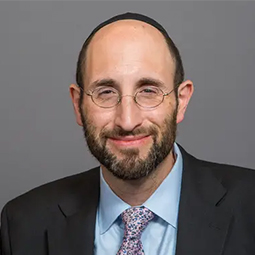Portrait of a man in a suit smiling at the camera.