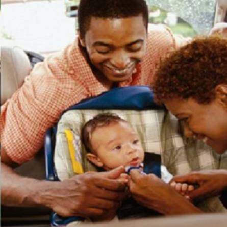 two people smiling at a baby in a stroller