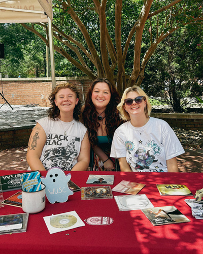 Group of students smiling while sitting at a table.