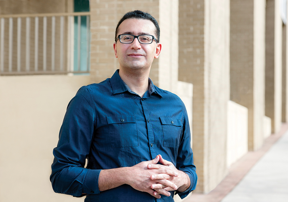 Roozbeh Behroozmand stands outside a building