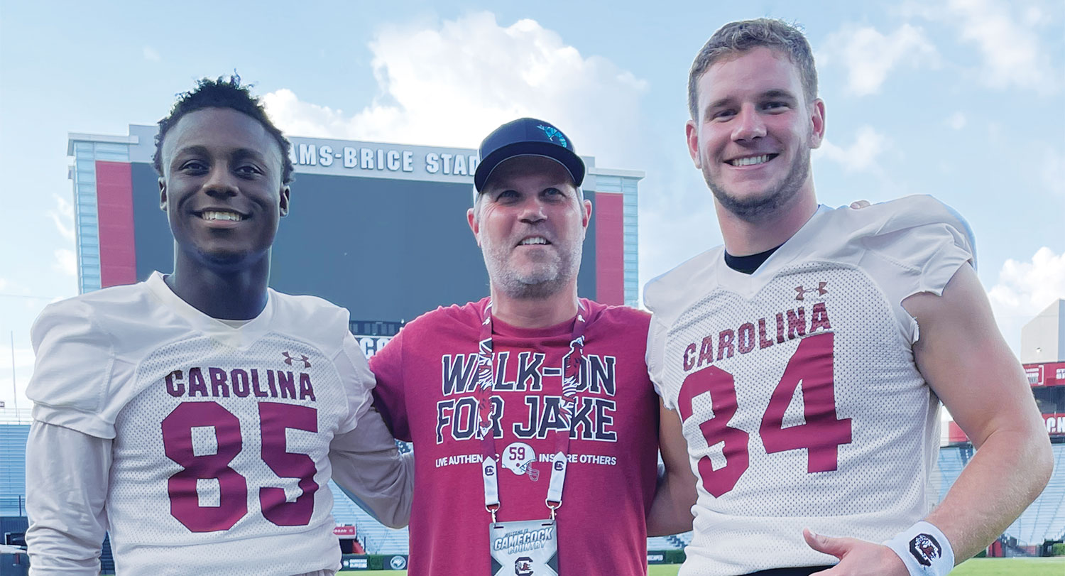 Stephen Panus, center, poses with the 2022 scholarship winner, wide receiver Payton Mangrum (left), and the 2021 winner, long snapper Matthew Bailey.