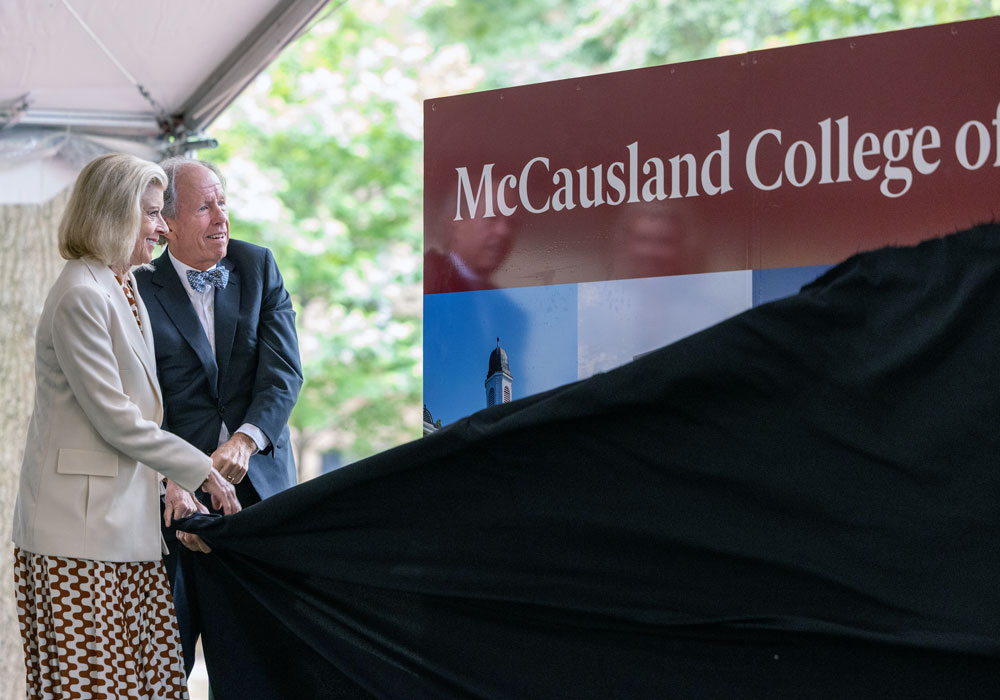 two people unveil a sign