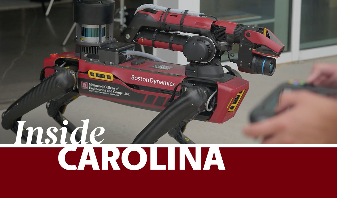 graphic that has a frame with the words Inside Carolina over an image of a robot "dog" and hands using a remote control