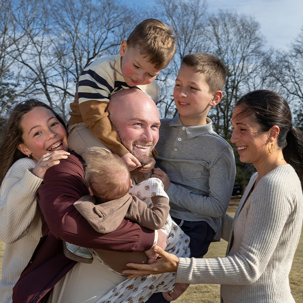 Connor Shaw, his wife and their four children are all smiles, posing together at a rec field