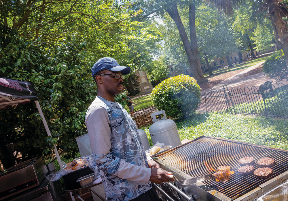 A student grills burgers at the Garden Grill, McCutchen on the Horseshoe.