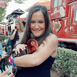 Caroline Waxman holding mascot gamecock Sir Big Spur.