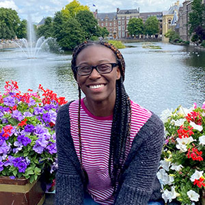 Photo of Jhy-Ann Walk sitting with flowers on the river in Amsterdam.