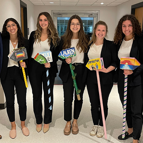 Lauren Speck stands with a group of students holding engineering name signs