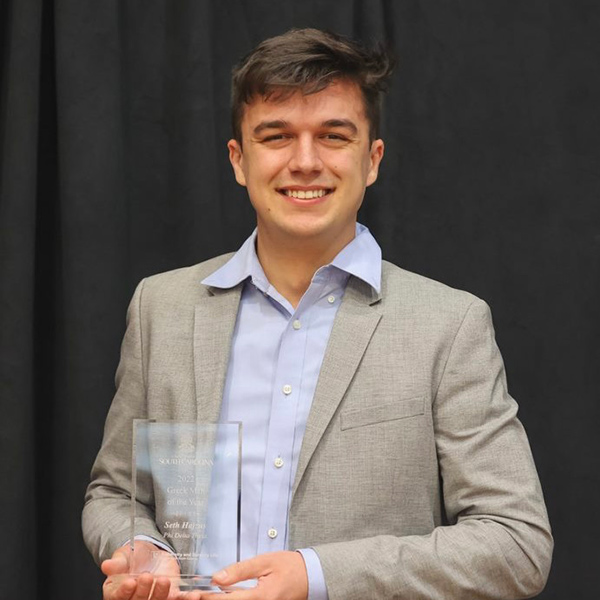 Seth Hajzus with the Greek Man of the Year award