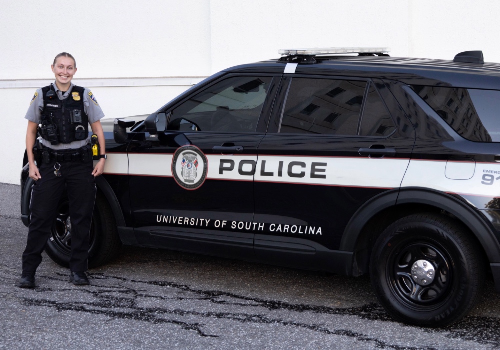 Officer Ava McGowen of the USCPD in front of her patrol car.